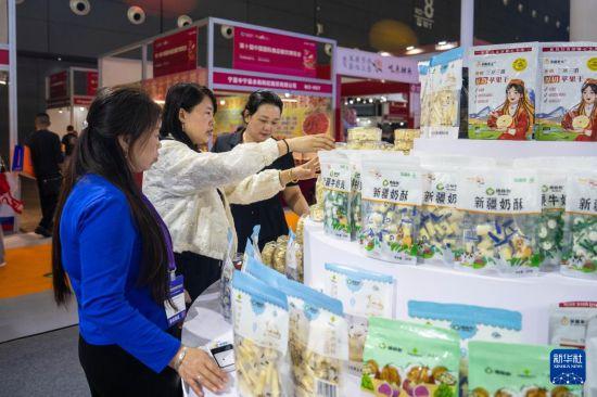 9月19日，在长沙国际会展中心，观众（中）在了解展出的奶制品。